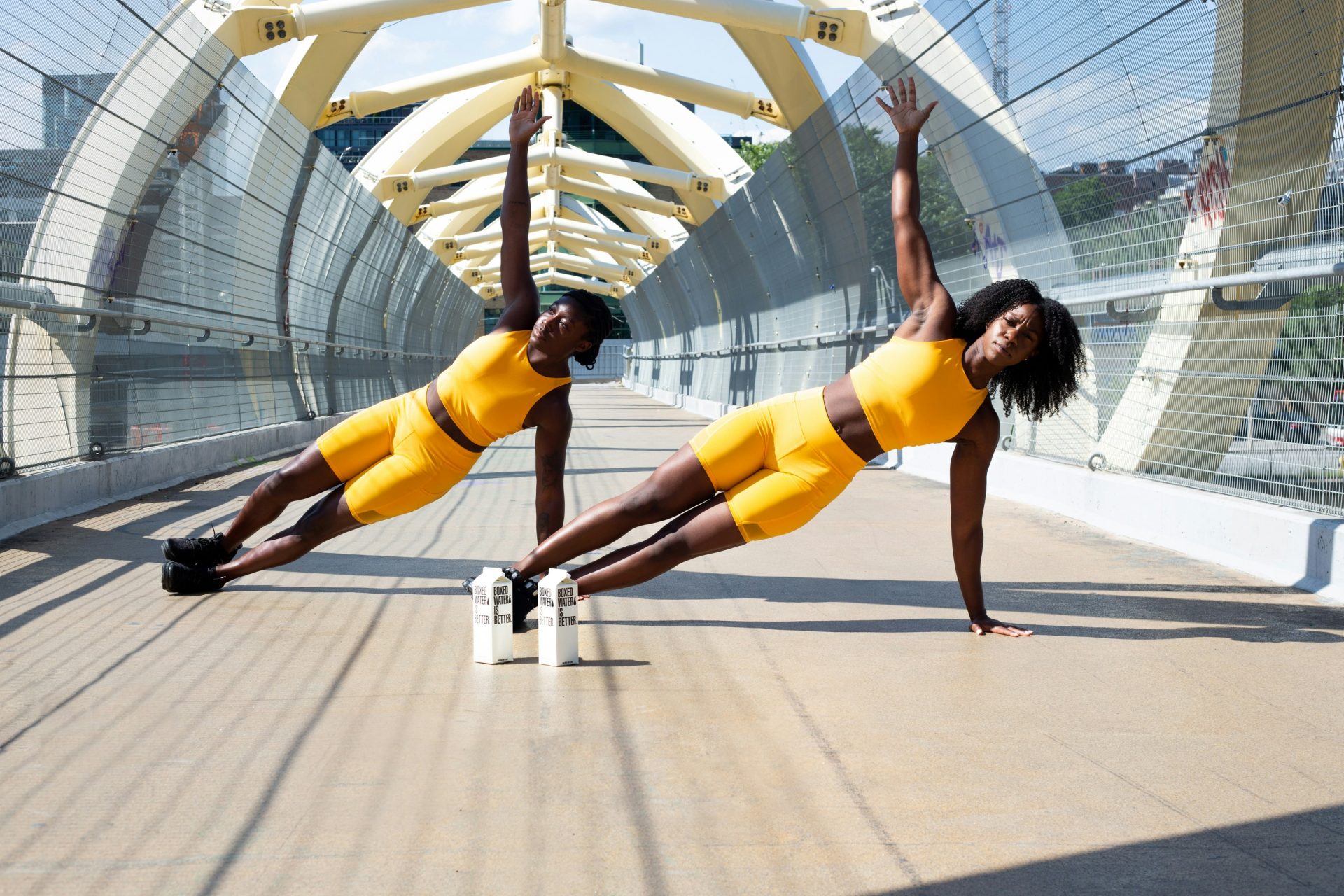 woman in yellow sports bra and yellow shorts jumping on white metal frame